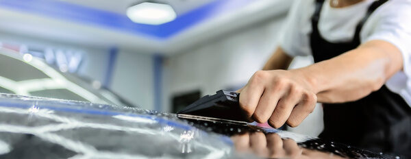 People detailing film paint protection men specialist cutting and wrapping bike in garage showroom for vehicle care service business concept.r